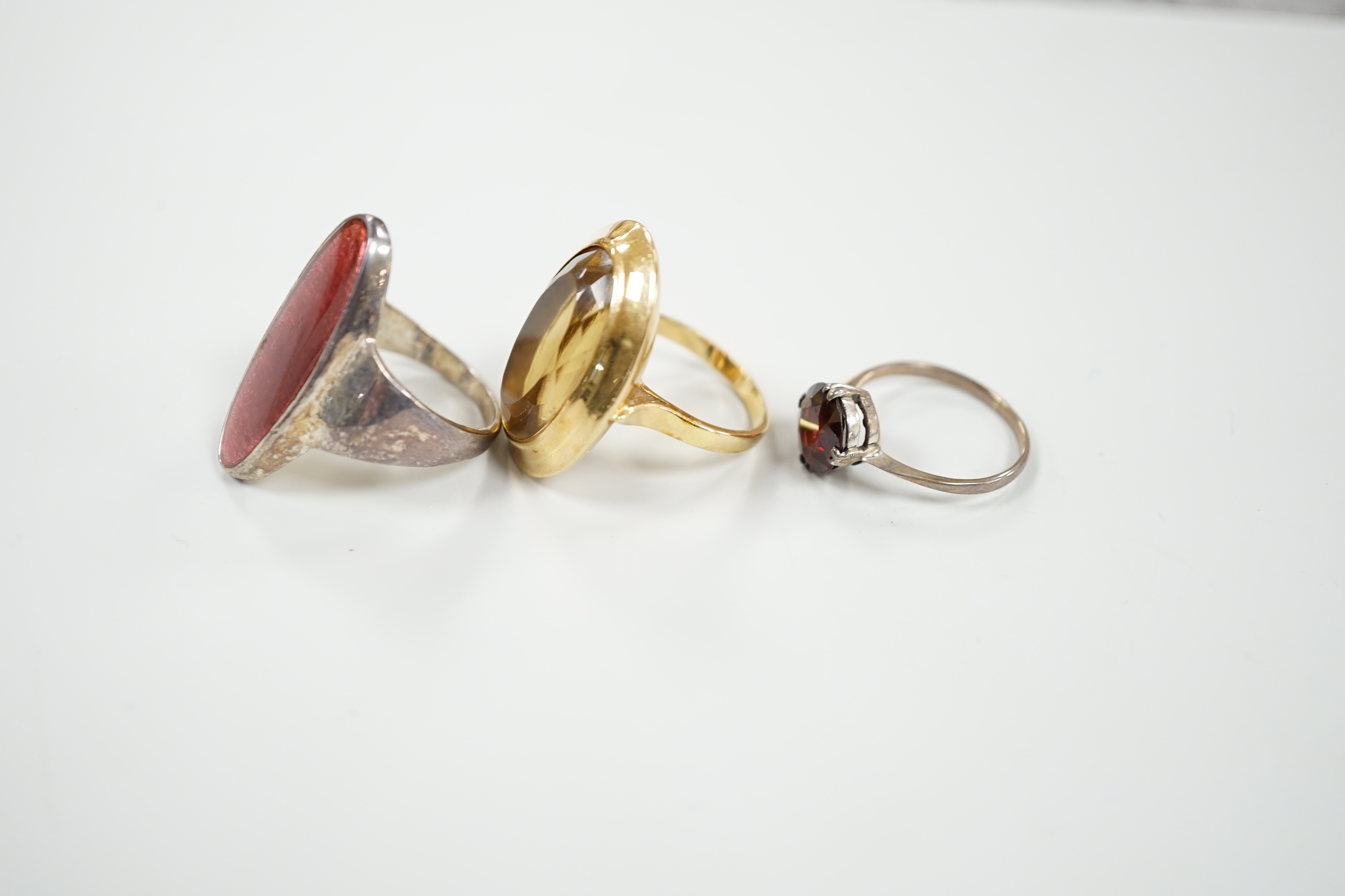 A yellow metal and oval cut citrine set dress ring, size M, gross 15.8 grams and two other rings.